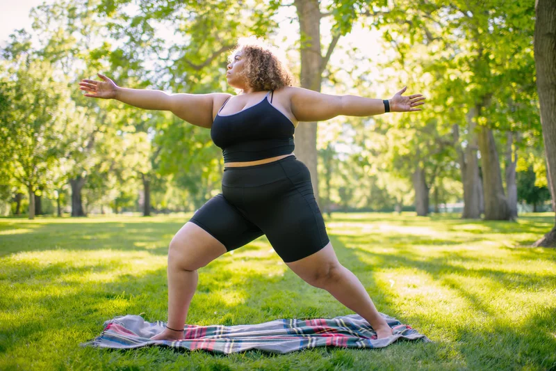 Femme qui pratique le yoga dans le parc