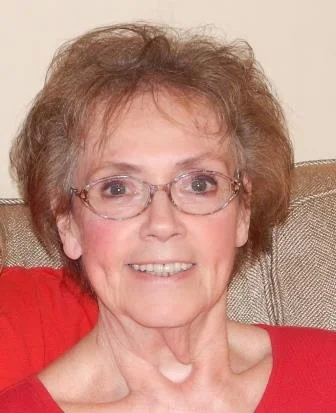 a woman with glasses smiling