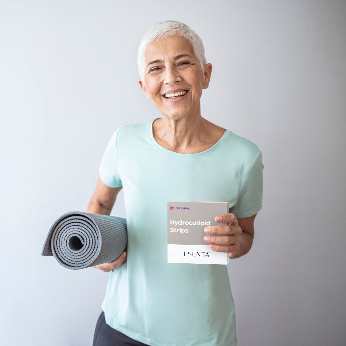 Frau mit Esenta Strips Packung und Yogamatte